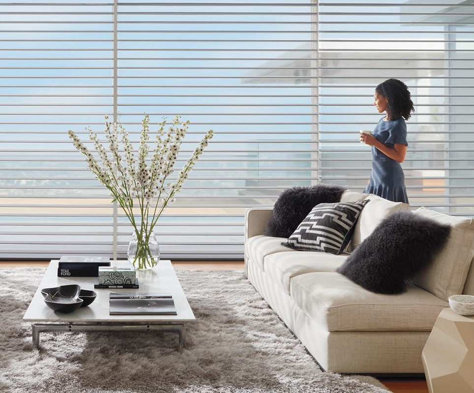 Woman looking out window with blinds